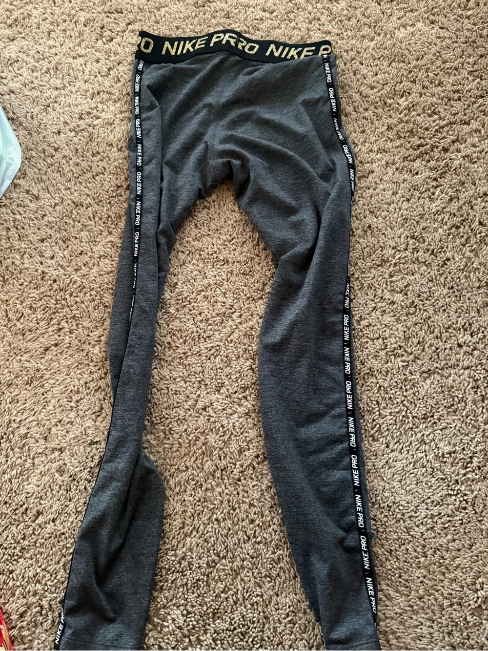 Nike women’s Charcoal Gray leggings with gold Swoosh